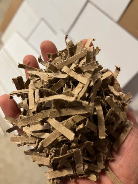 Close up image of hand holding mechanically Shredded Cardboard 